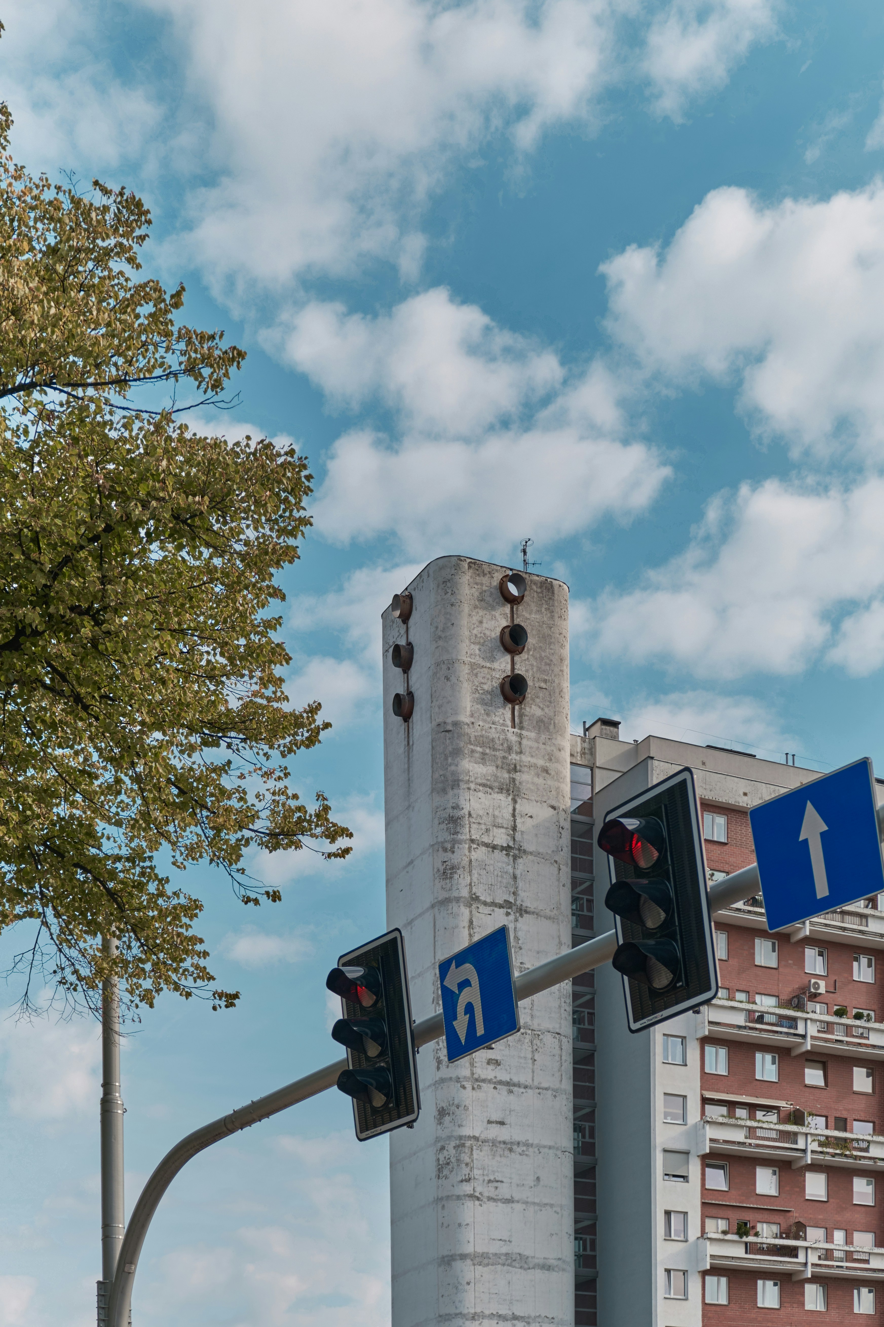 a traffic light with a tall building in the background