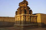 A vibrant photo of an ancient Indian temple with intricate carvings under warm sunlight.