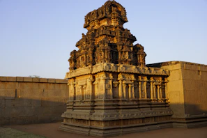 A vibrant photo of an ancient Indian temple with intricate carvings under warm sunlight.