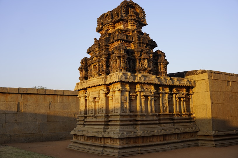 A vibrant photograph of an ancient temple carved in stone, bathed in golden sunlight.
