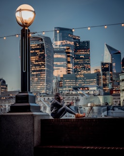 Person using a cutting-edge gadget outdoors, with cityscape in background.
