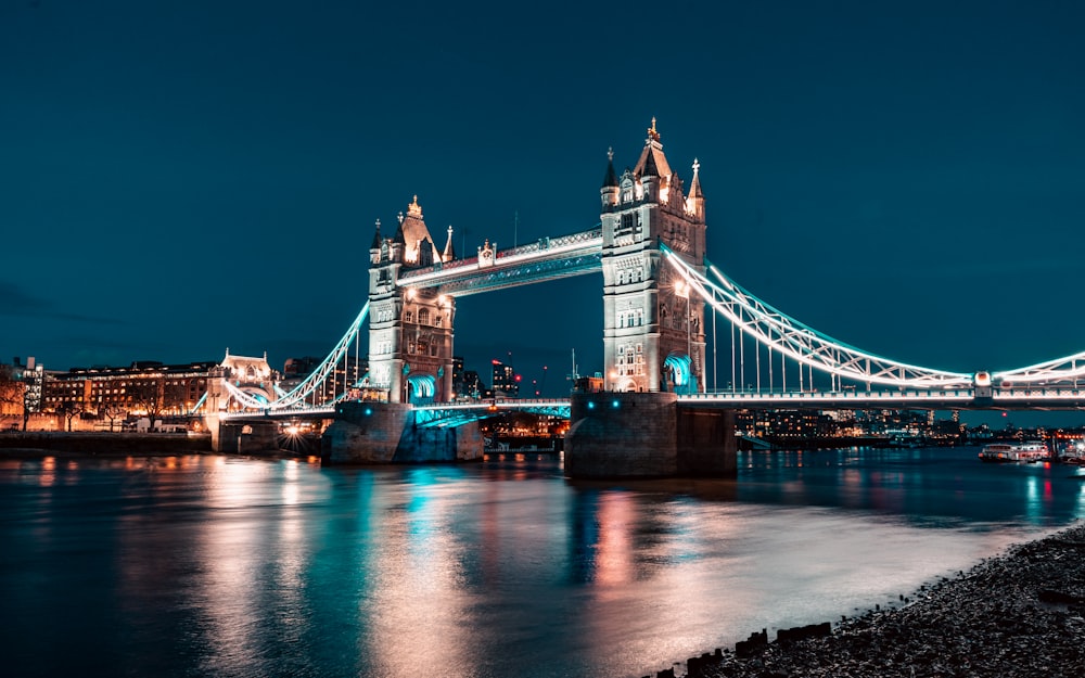 the tower bridge is lit up at night