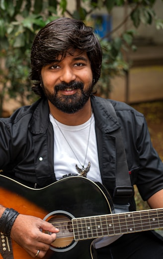 a man with a beard holding a guitar