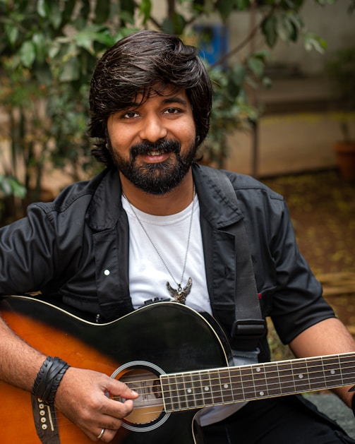 a man with a beard holding a guitar