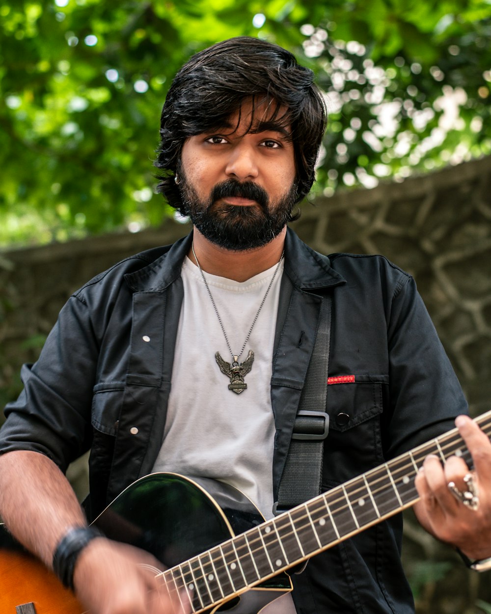 a man with a beard playing a guitar