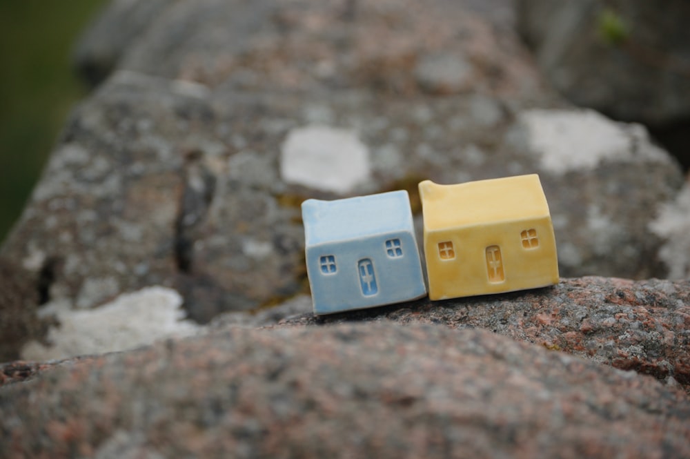 a couple of small houses sitting on top of a rock