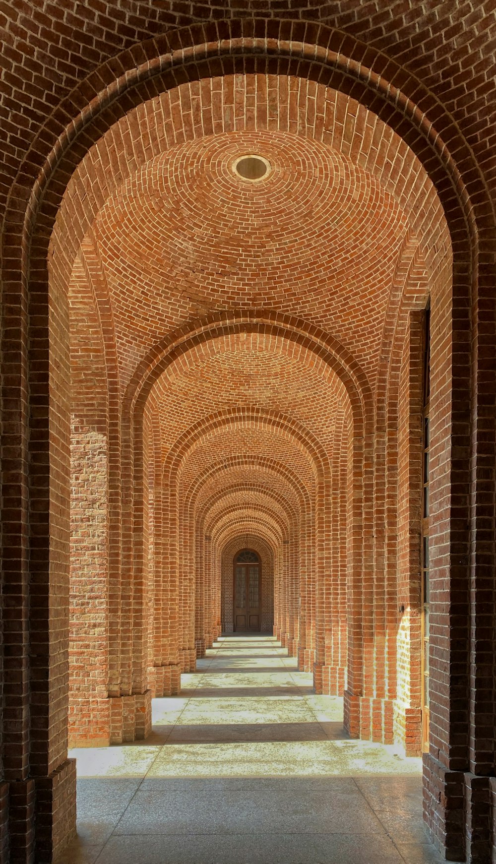 a long brick walkway lined with columns and arches