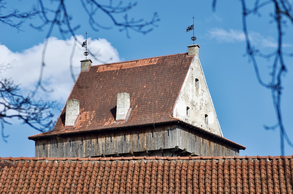 a building with a brown roof and two chimneys