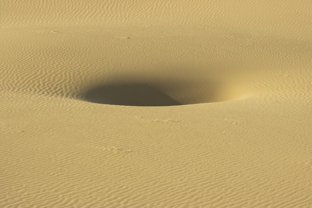 a small hole in the sand in the desert
