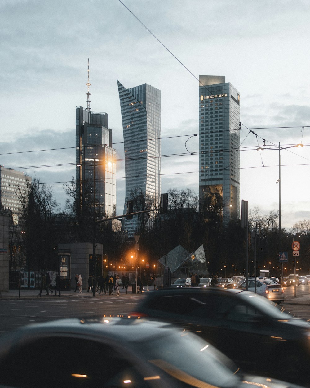 a city street filled with lots of traffic next to tall buildings