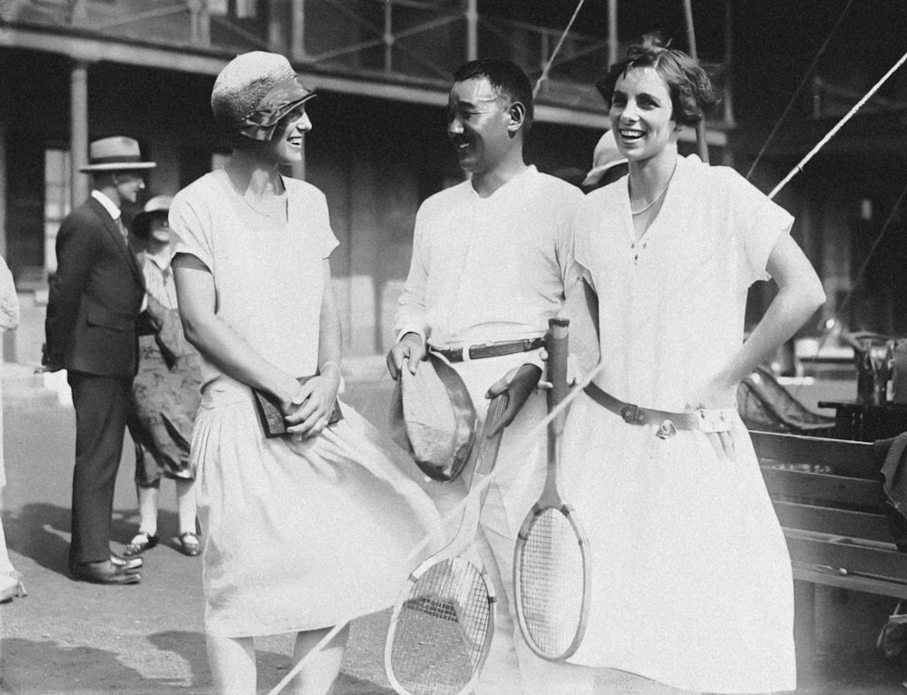 a group of people standing next to each other holding tennis racquets