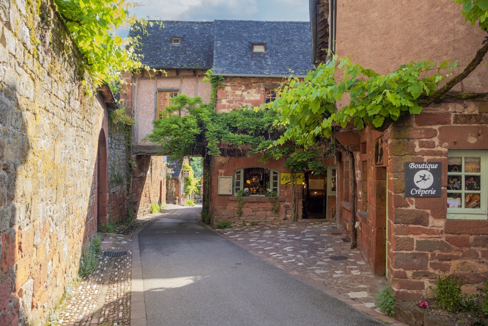 an alley way with a stone building and a clock on the wall