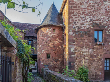 The inviting exterior of 'Le Roc del Four' framed by ancient medieval stonework.