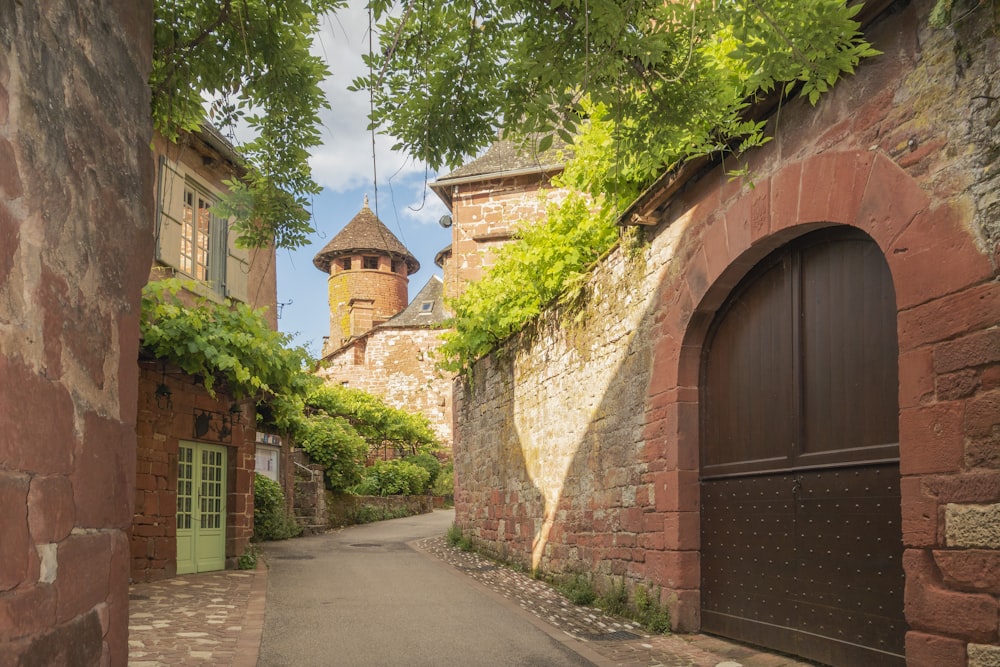 an alley way with a gate and a tower in the background