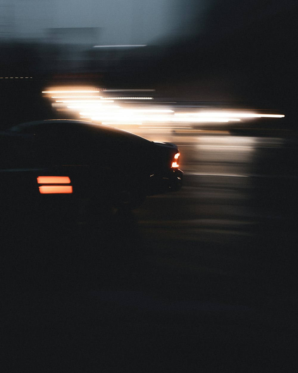 a car driving down a street at night