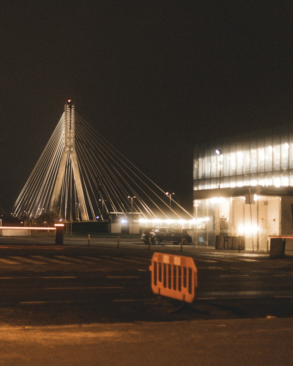 a building with a bridge in the background at night