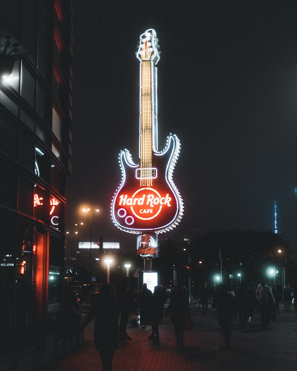 a guitar sign is lit up in the dark