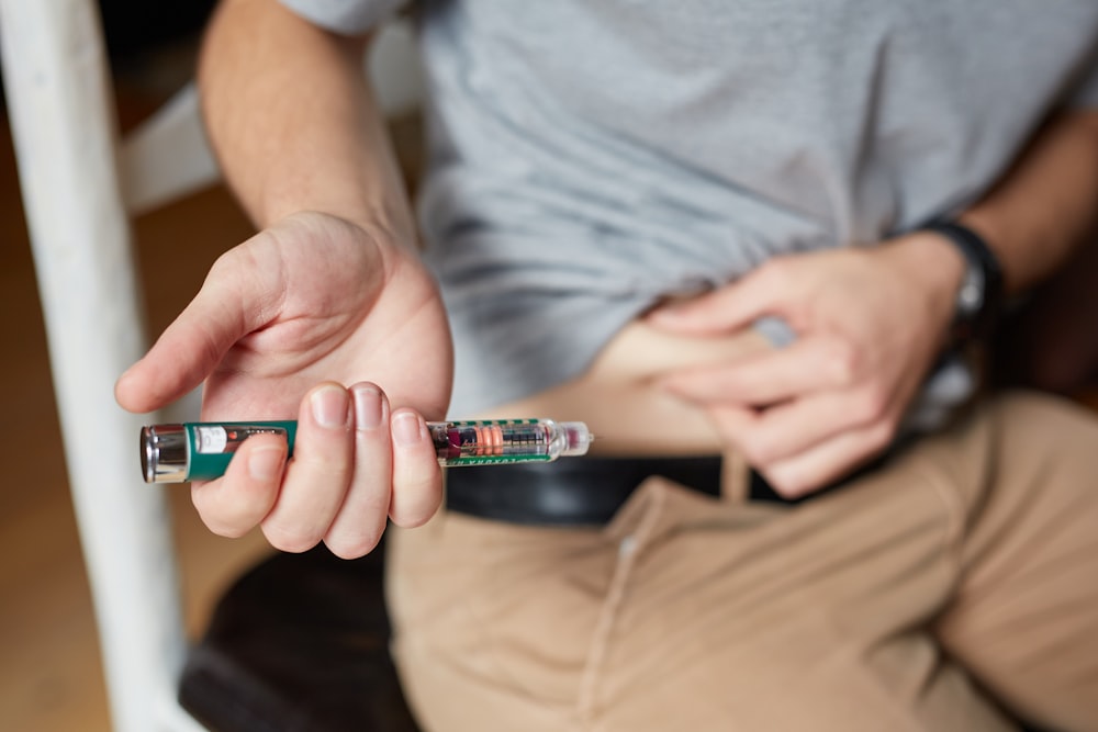 a man sitting down holding an electronic device