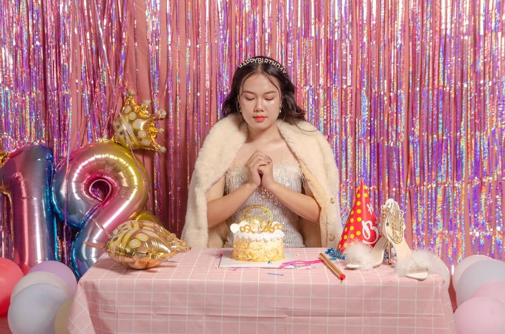 a woman standing in front of a table with a cake