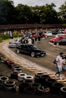 Wide shot of a car meet with various high-performance vehicles parked outdoors.