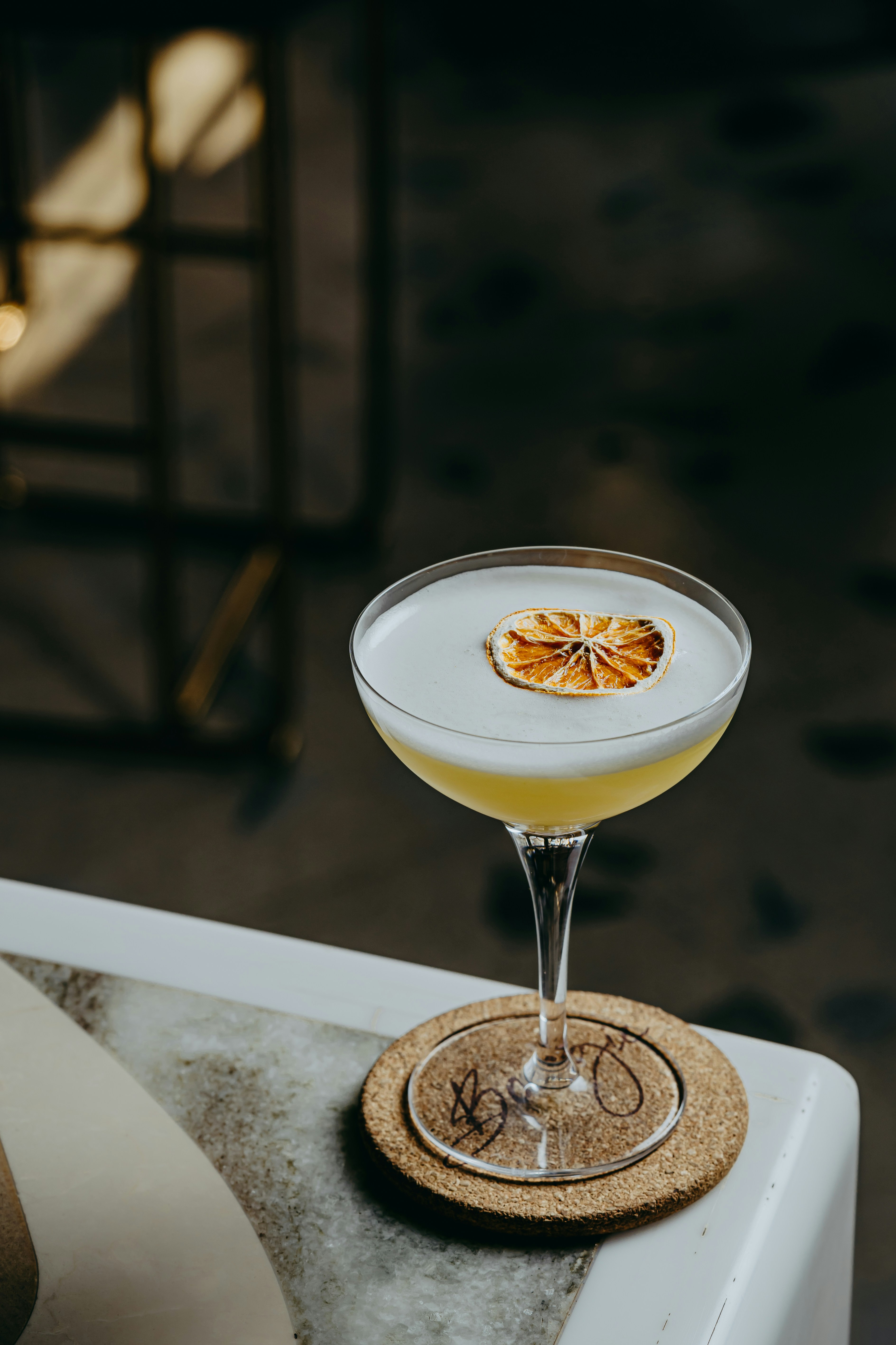 a glass filled with a drink sitting on top of a table