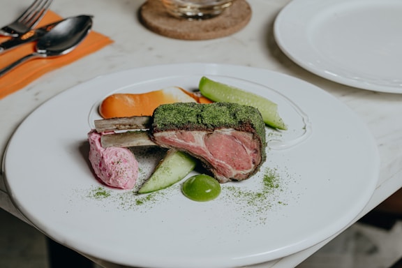 A beautifully plated dish of lamb tajine with vibrant vegetables and fragrant spices.