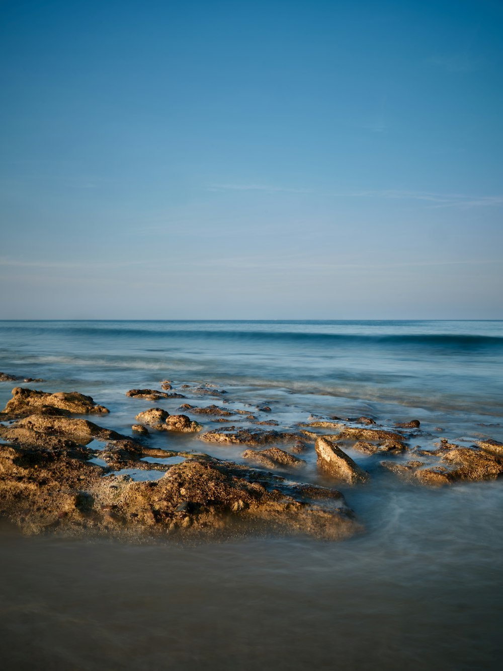 a view of a body of water with rocks in the foreground