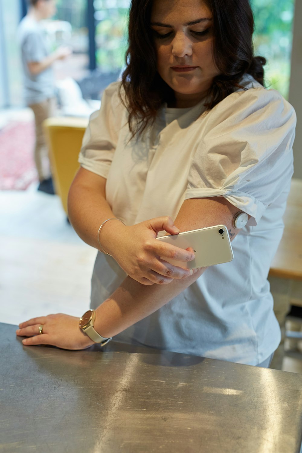 a woman standing at a counter using a cell phone