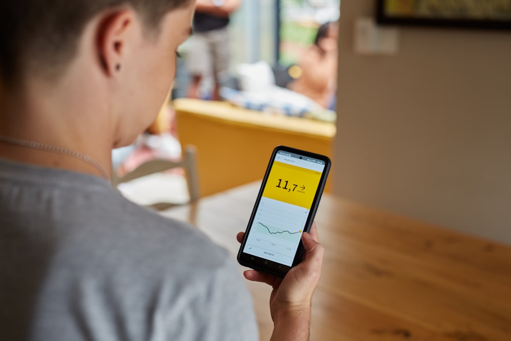 a person looks at high blood glucose results on smart phone