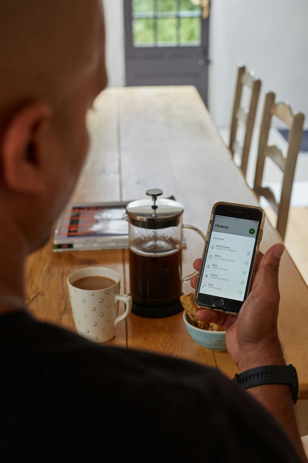 a man sitting at a table looking at his cell phone