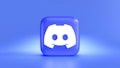 A three-dimensional blue cube featuring a white, stylized gaming controller symbol associated with a popular communication platform, set against a gradient blue background.