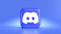 A three-dimensional blue cube featuring a white, stylized gaming controller symbol associated with a popular communication platform, set against a gradient blue background.