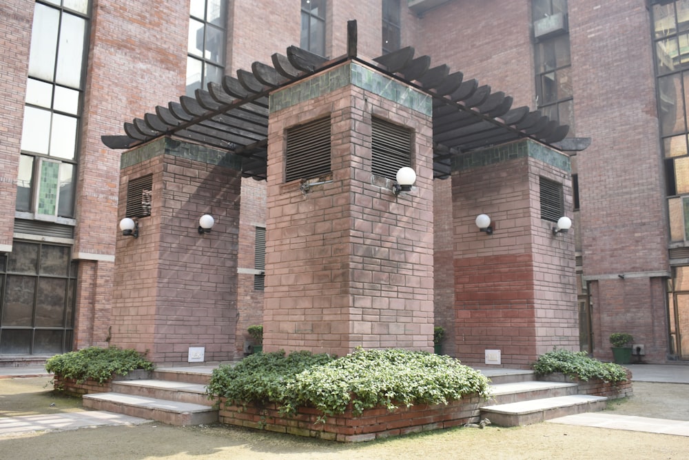 a couple of brick buildings with plants in front of them