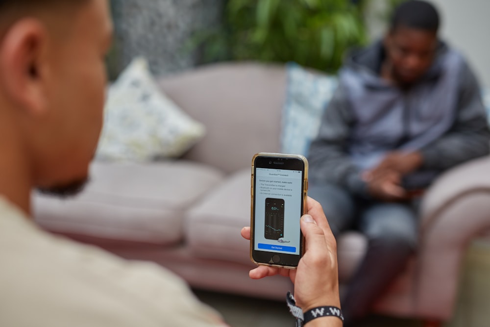 Un homme tenant un téléphone intelligent à la main