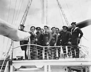 a group of men standing on top of a boat
