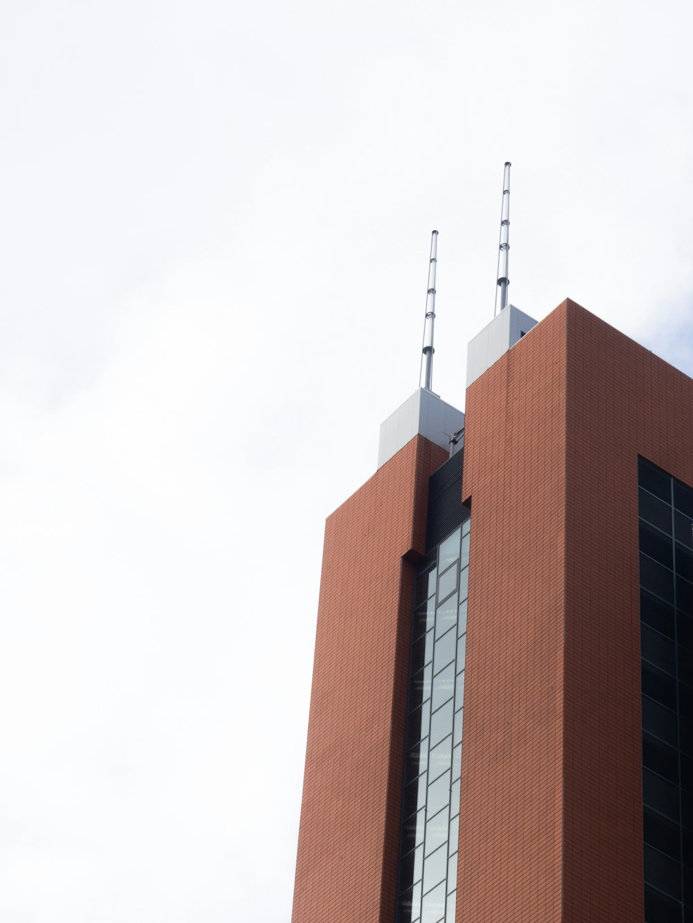 a tall red brick building with two antennas on top