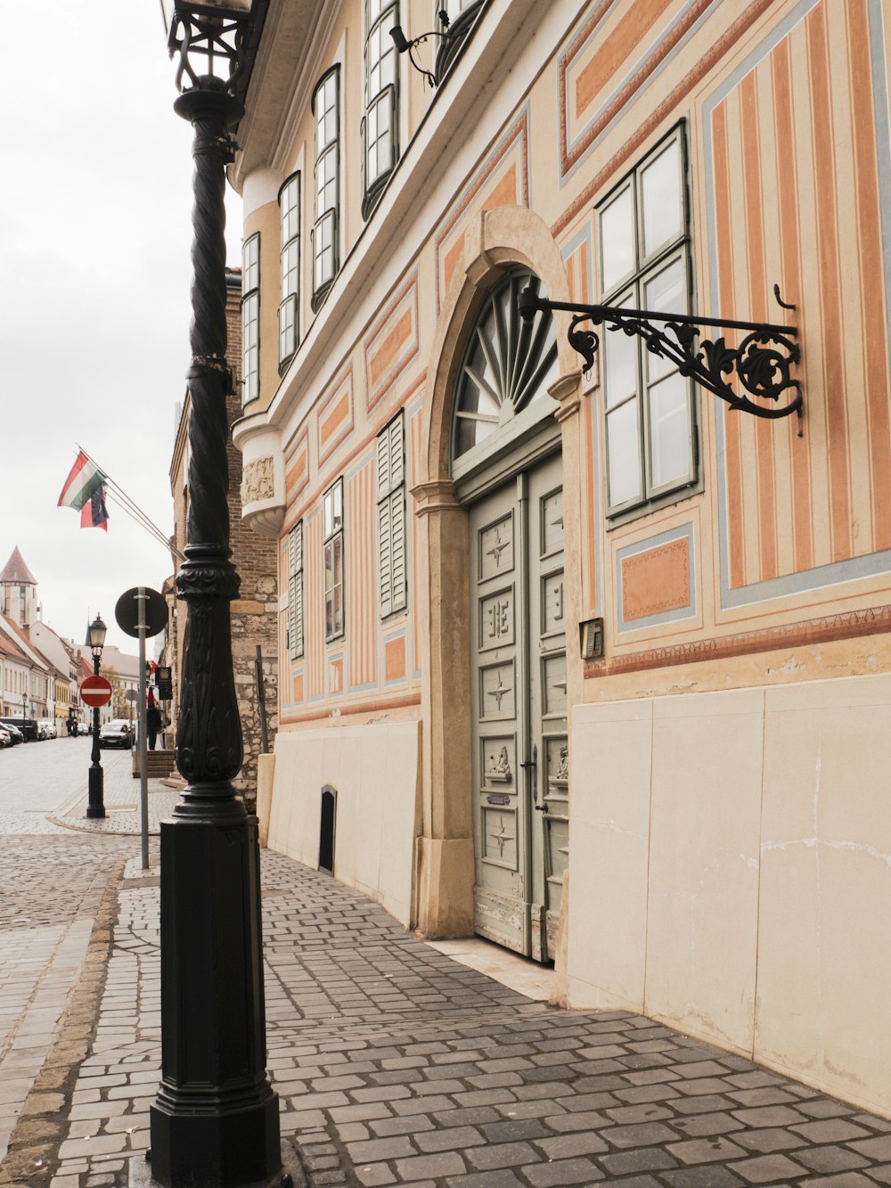 a street light on a brick sidewalk next to a building