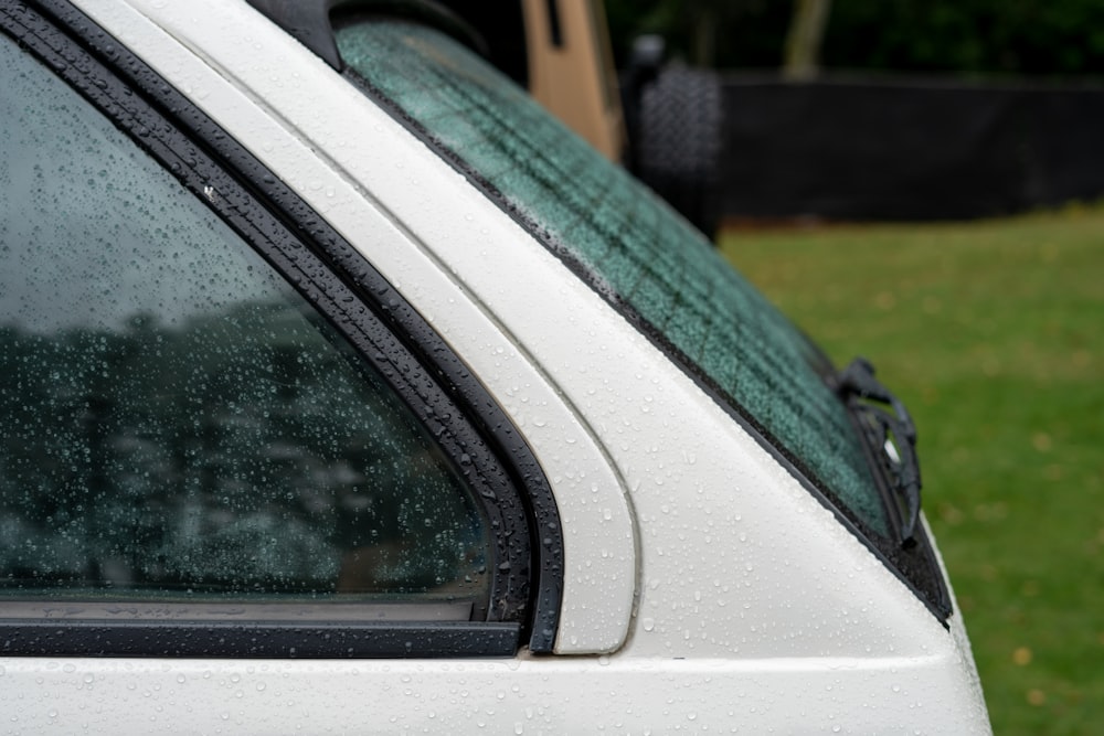 a white car with rain drops on the windshield