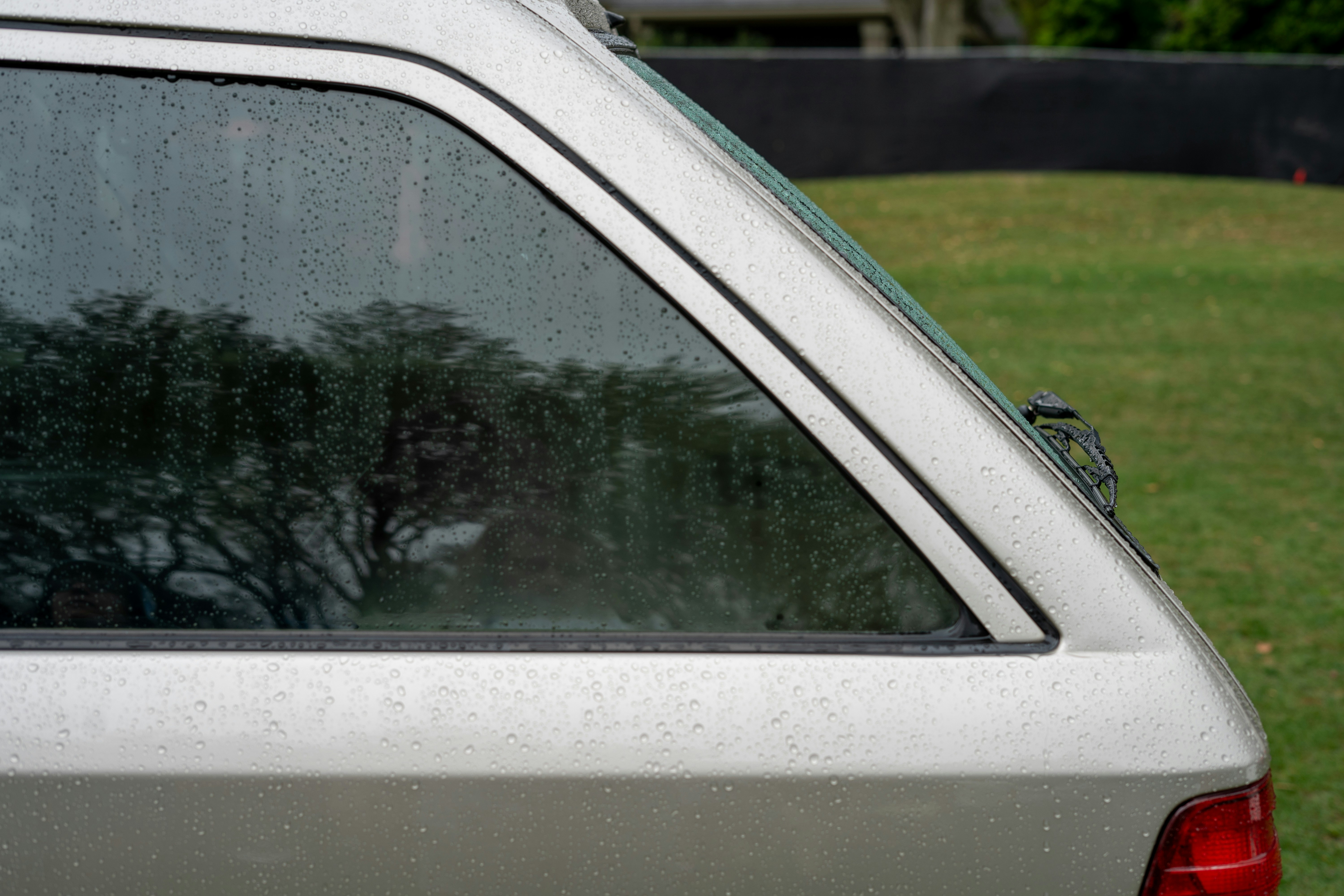 the back of a car with rain drops on it