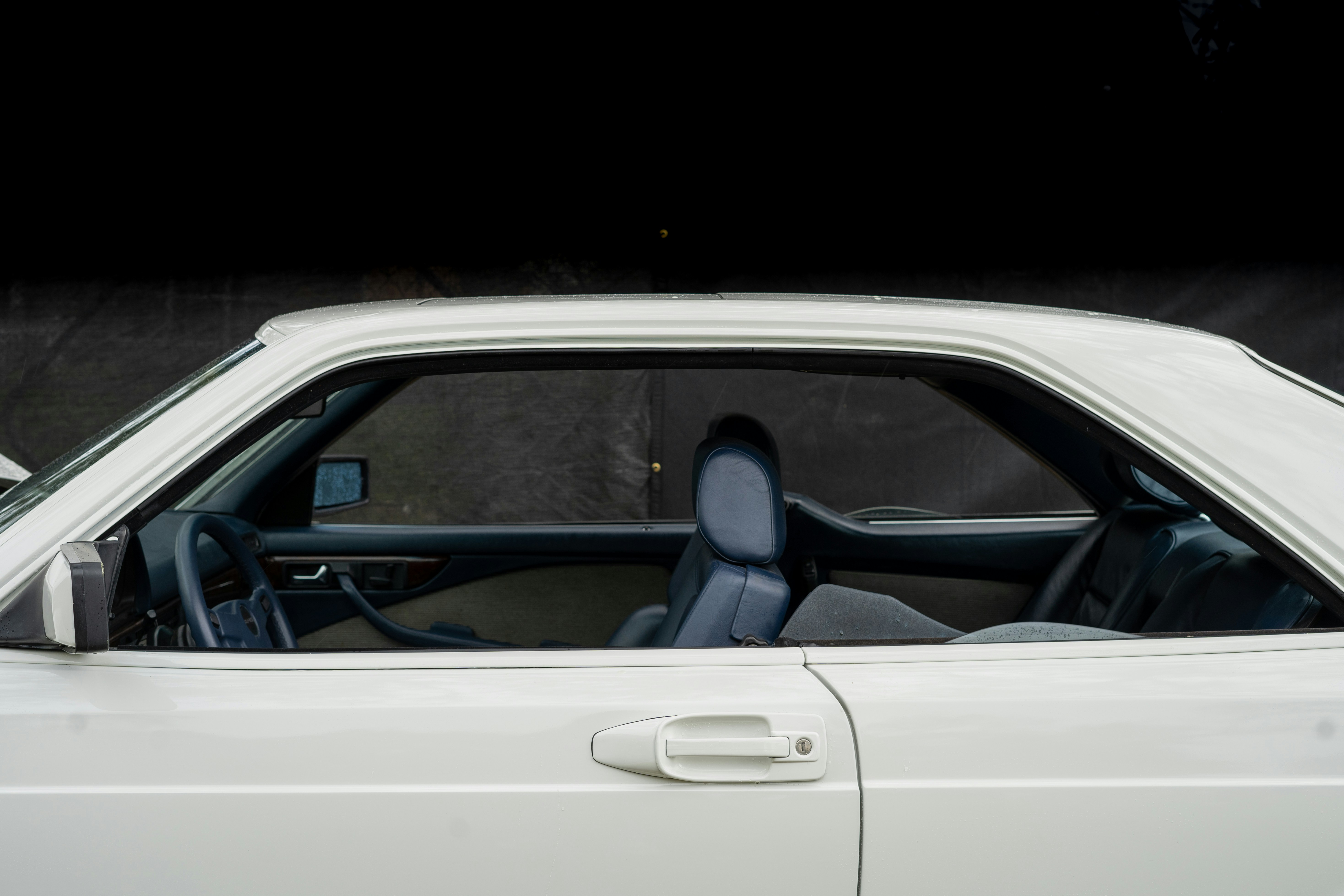 the interior of a white car with the door open, 