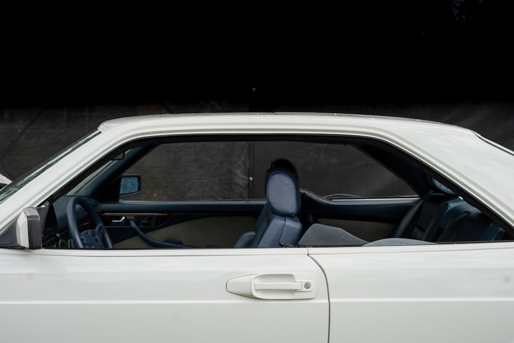 the interior of a white car with the door open