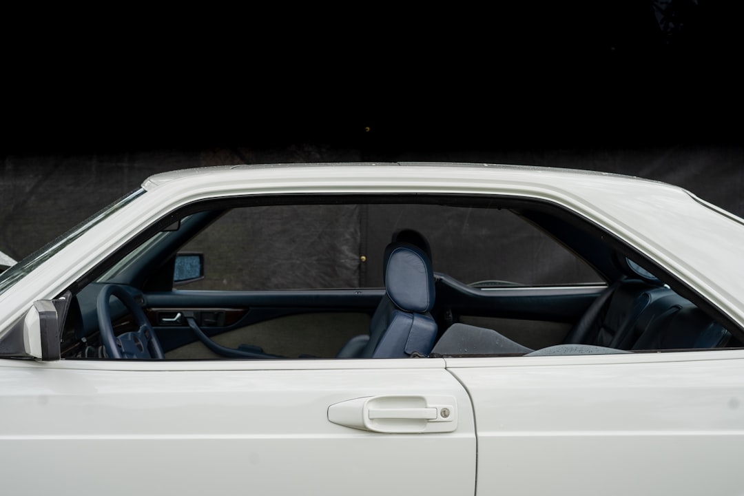 the interior of a white car with the door open,