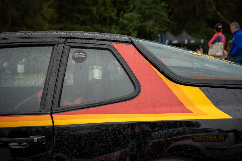 a black car with a yellow and red stripe