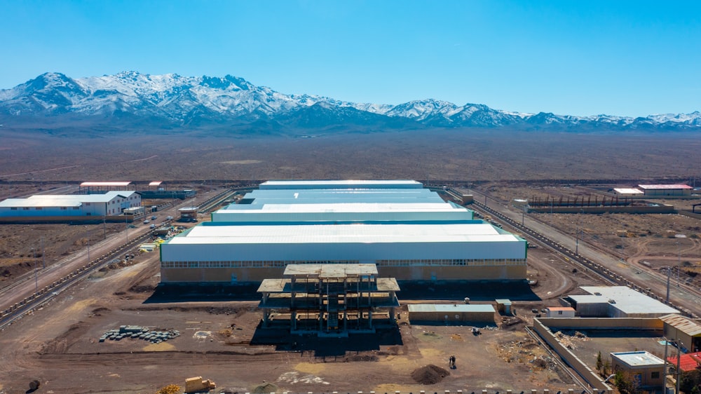 an aerial view of a factory with mountains in the background