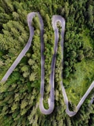 An aerial view of a scenic road winding through forests.