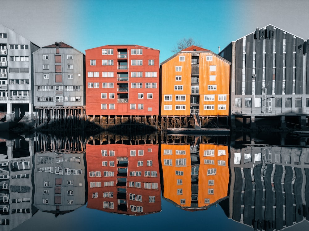 a group of buildings reflecting in a body of water