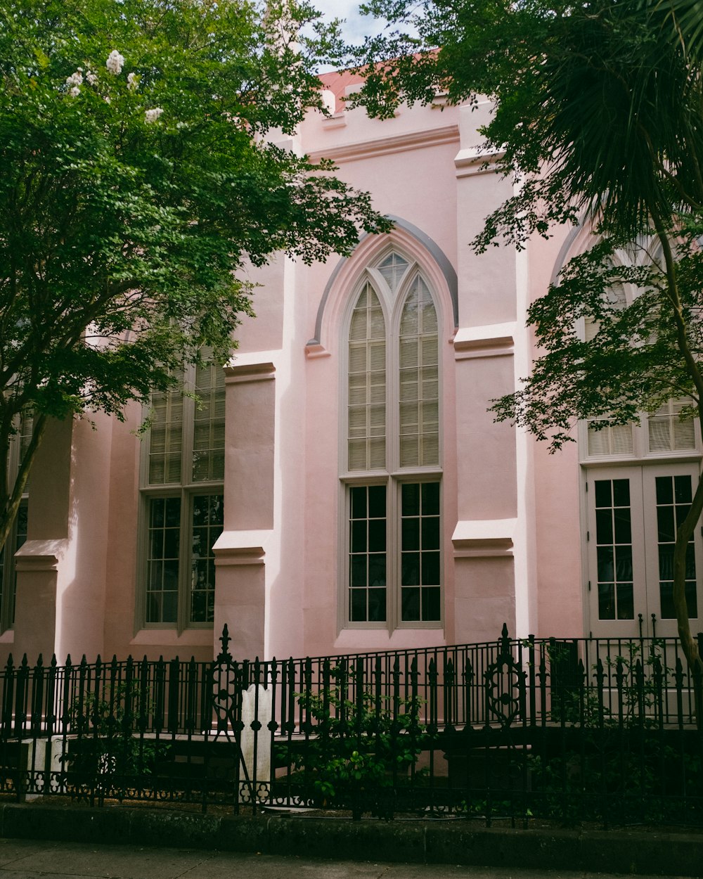 a pink building with a black fence around it