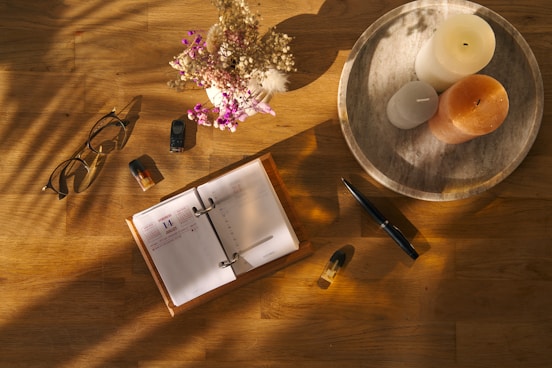 a wooden table topped with a book and a candle