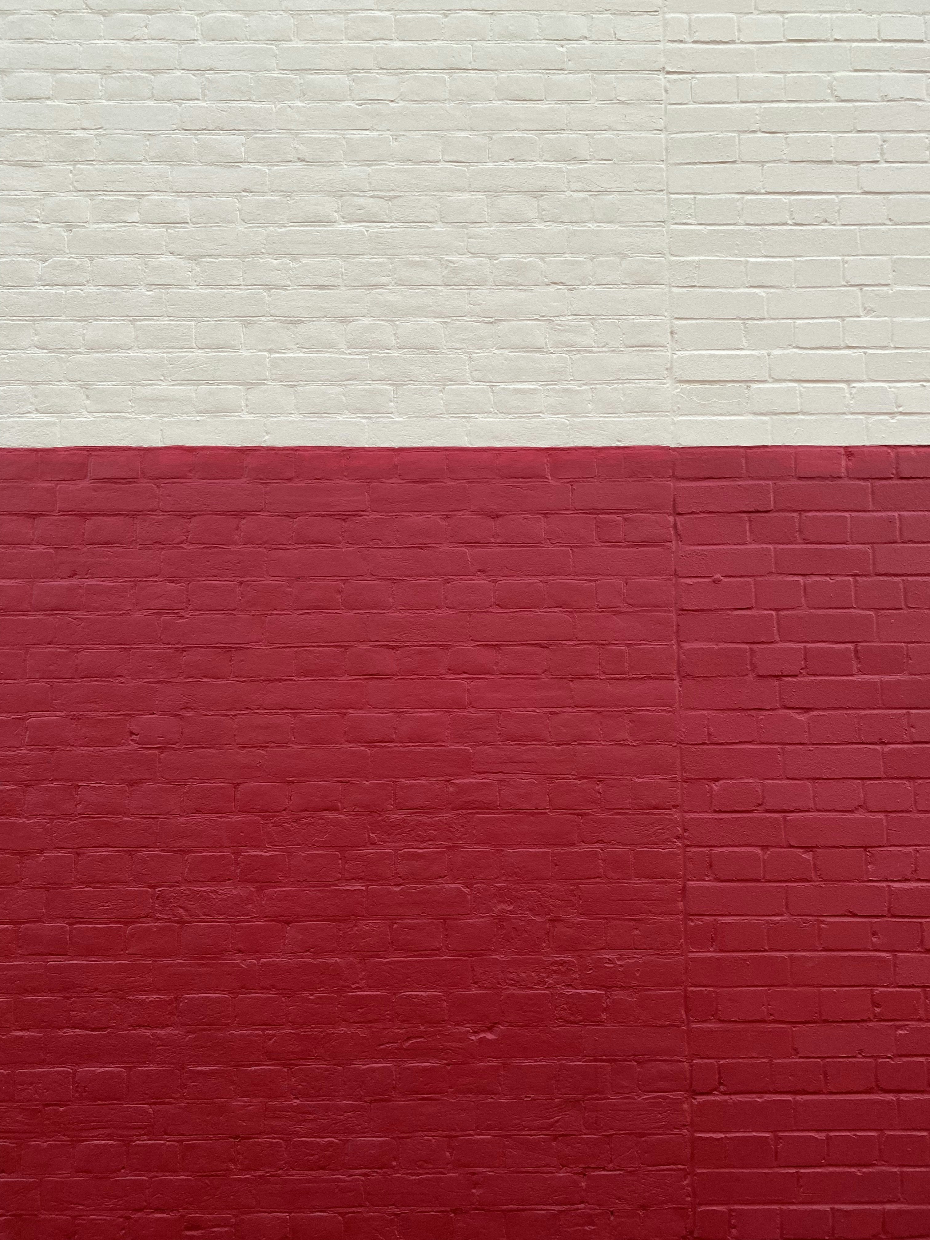 a red and white wall with a clock on it