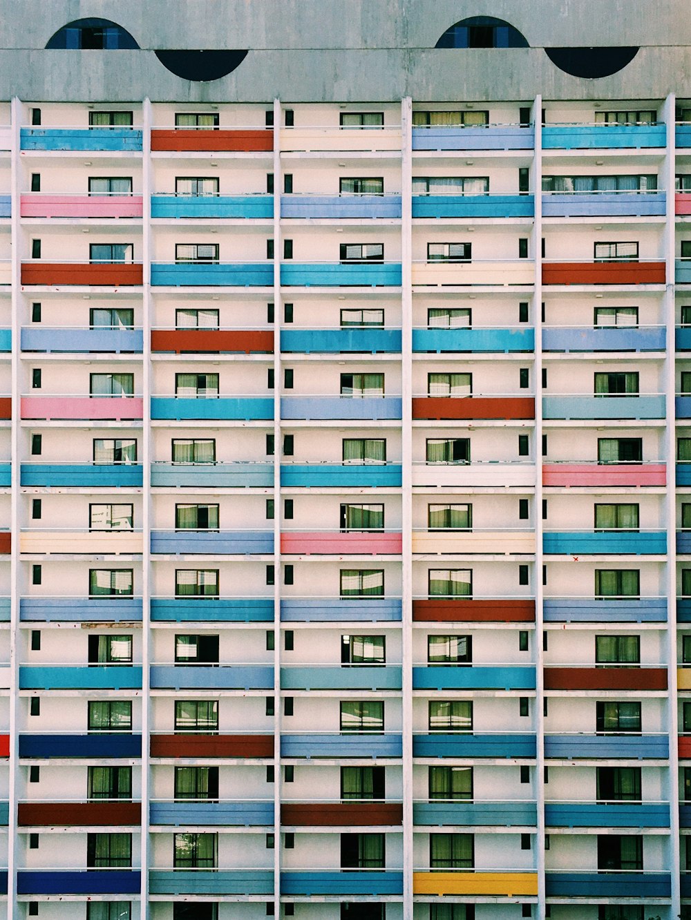 Un edificio multicolor con ventanas y balcones